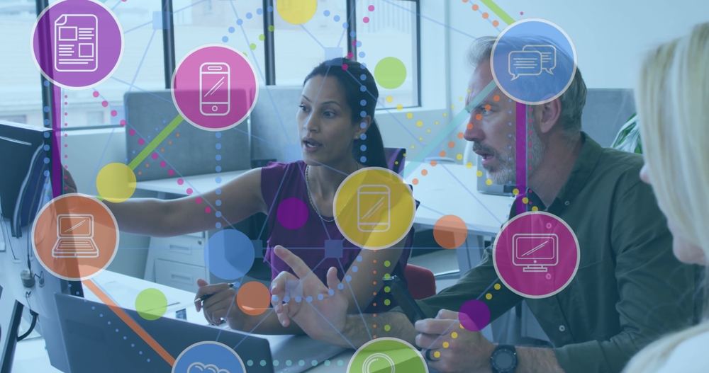 People discussing information on computer screen in office setting.